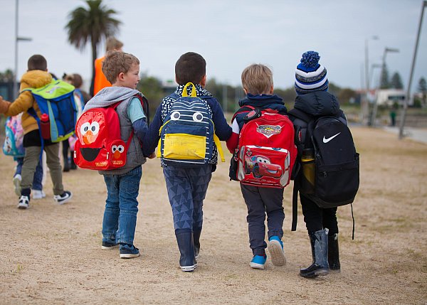 kinder children walking with backpacks