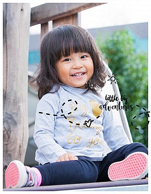 happy girl on a slide or slippery dip at kindergarten or childcare