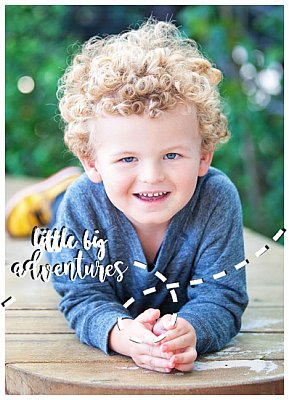 happy curly haired boy smiling and posing for the camera at kinder or childcare